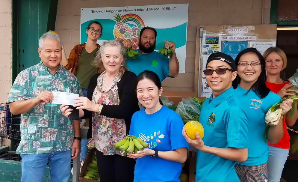 Honua Ola employees giving back to the community and presenting a check to the local food bank