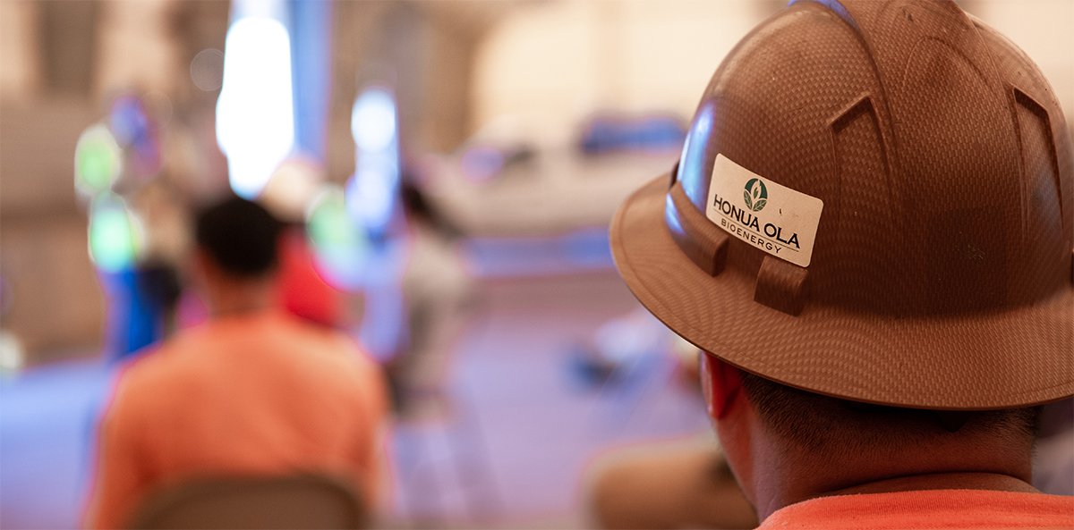Rear view of a man's helmet with the Honua Ola logo